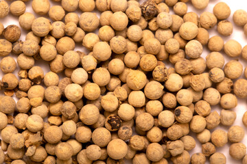 White pepper, spice close-up flat lay on a white background. Indian and Arabic spices for cooking. Medicinal herbs and spices.