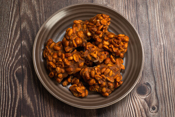 Peanut candy served in a brown silver on wooden background.