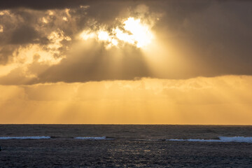 raios de sol passando por uma nuvem com a vista do mar durante um amanhecer