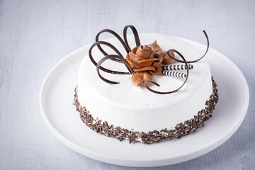 Cheesecake on a light table. The cake is decorated with chocolate