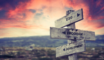 esg program development text quote caption on wooden signpost outdoors in nature with dramatic sunset skies. Panorama crop. ESG Concept