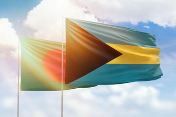 Sunny blue sky and flags of bahamas and bangladesh
