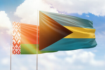 Sunny blue sky and flags of bahamas and belarus