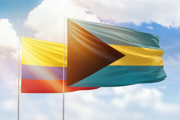 Sunny blue sky and flags of bahamas and colombia