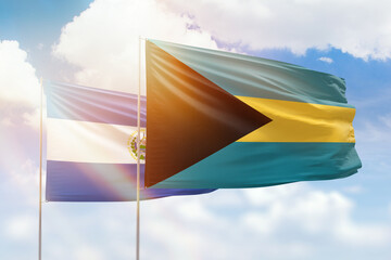 Sunny blue sky and flags of bahamas and el salvador