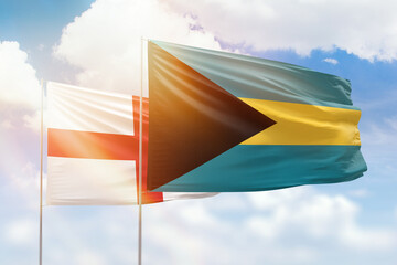 Sunny blue sky and flags of bahamas and england