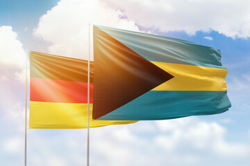 Sunny blue sky and flags of bahamas and germany