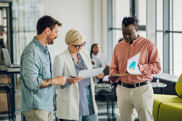 Obraz premium Multiracial business colleagues discussing about documents in the office