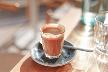 A coffee sitting on a table at a cafe