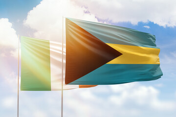 Sunny blue sky and flags of bahamas and ireland
