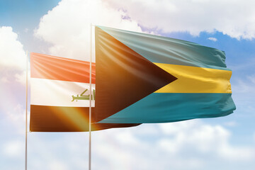 Sunny blue sky and flags of bahamas and iraq