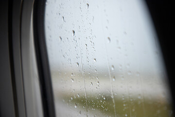 Airplane window with raindrops bokeh