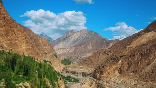Gorge among the mountains, trees and clouds in the blue sky
