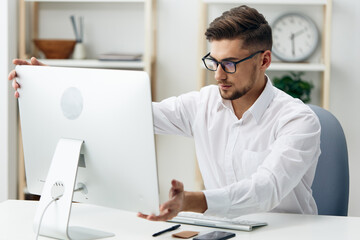 businessmen in a white shirt sits at a computer work documentation technologies