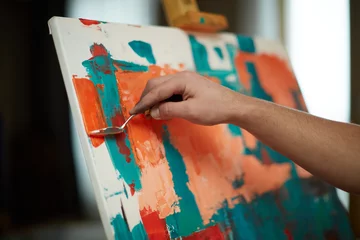 Fotobehang Schilderij Close-up creative artist painting abstract artwork, add more details with brushstrokes by palette knife on canvas  © Georgii