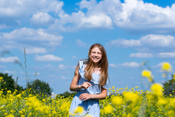 Happy smiling teenage girl having fun in nature. Ukrainian girl on yellow and blue background. Colors of Ukrainian flag.