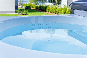 A hot tub in a terrace with a beautiful lake view. A well-kept garden on a beautiful summer's day....