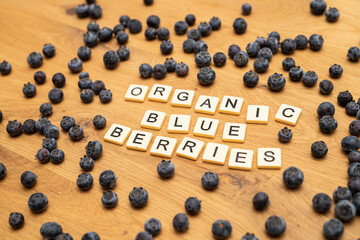 healthy organic blueberries letters on wood background