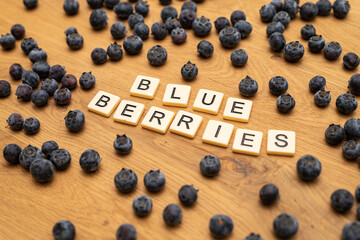 healthy organic blueberries letters on wood background