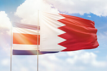 Sunny blue sky and flags of bahrain and costa rica