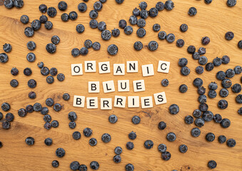 healthy organic blueberries letters on wood background