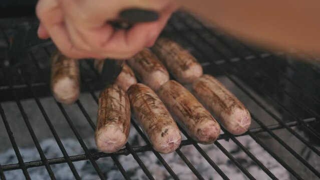 Spicy Sausages Being Grilled Over Bright Glowing Coals Broasting On Fire. Lunch Celebration Party Barbecue. Outdoor Cooking. Cook Prepares Oriental Dish In Kitchen. Junk Food, Healthy Lifestyle.