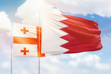 Sunny blue sky and flags of bahrain and georgia