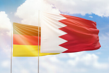 Sunny blue sky and flags of bahrain and germany