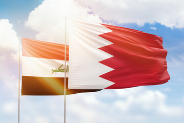 Sunny blue sky and flags of bahrain and iraq