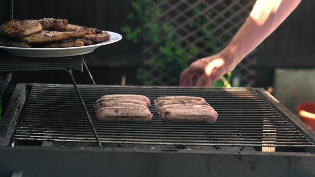 Spicy Sausages Being Grilled Over Bright Glowing Coals Broasting On Fire. Lunch Celebration Party Barbecue. Outdoor Cooking. Cook Prepares Oriental Dish In Kitchen. Junk Food, Healthy Lifestyle.