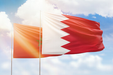 Sunny blue sky and flags of bahrain and morocco