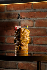 Tropical cocktail - zombie, served in a tiki style with fruits and flowers. An exotic cocktail in a...