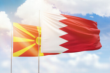 Sunny blue sky and flags of bahrain and north macedonia