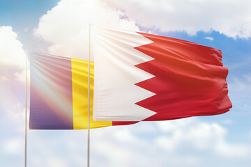 Sunny blue sky and flags of bahrain and romania