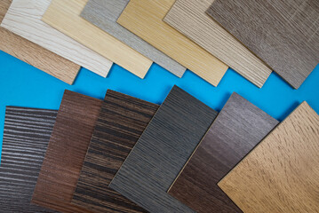Naklejka na ściany i meble Laminate boards on blue. Samples of laminate or parquet with a pattern and texture of wood for flooring and interior design.