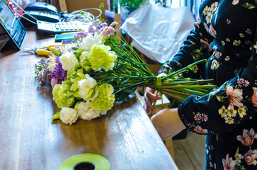 florist tying a bouquet of flowers daylight