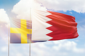 Sunny blue sky and flags of bahrain and sweden