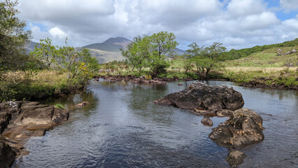 une rivière au sein d'un paysage sauvage entre plaine et montagnes irlandaises
