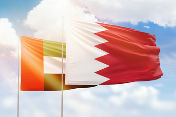 Sunny blue sky and flags of bahrain and uae