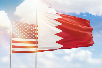 Sunny blue sky and flags of bahrain and usa