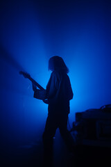 Guitarist silhouette on a stage in blue backlights 