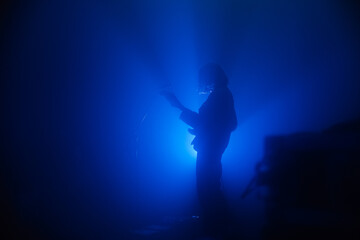 Guitarist silhouette on a stage in blue backlights 