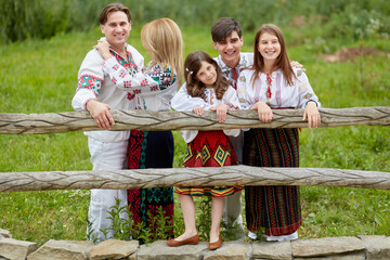 Beautiful family with kids in traditional clothes posing in a countryside, . Father, mother, son...