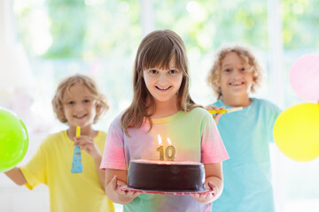 Kids birthday party. Child blowing out cake candle