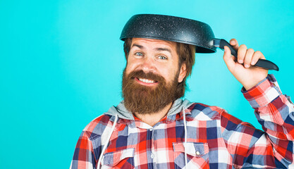 Kitchenware. Bearded man with frying pan on head. Cooking utensils. Crazy chef with frypan.