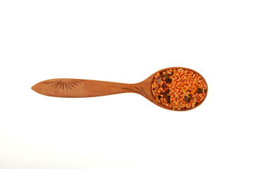 Lentils with spices in wooden spoon on white background, close-up. Ingredients for Indian Masurdal soup. Dry legumes. Long-term storage Healthy Food