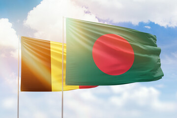 Sunny blue sky and flags of bangladesh and belgium