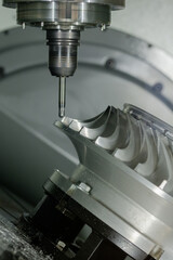 Close up: cnc vertical turning milling machine cutting metal workpiece at factory, exhibition, plant. Metalworking, engraving, equipment, industrial, technology and manufacturing concept