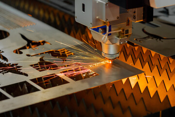 Automatic cnc laser cutting machine working with sheet metal with many sparks at factory, plant....