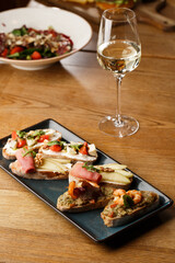 Bruschettas with vegetables. Start dishes with cherry tomatoes, avocado, cream cheese and shrimps. Food composition, tasty italian meal